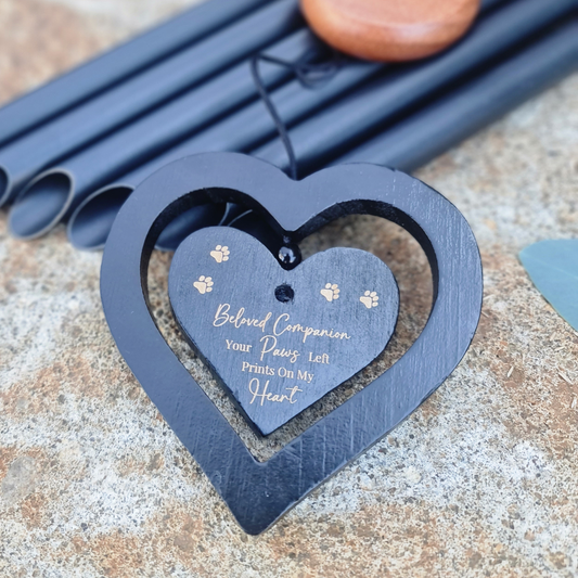 Heart-shaped pet memorial with engraved text on a textured surface